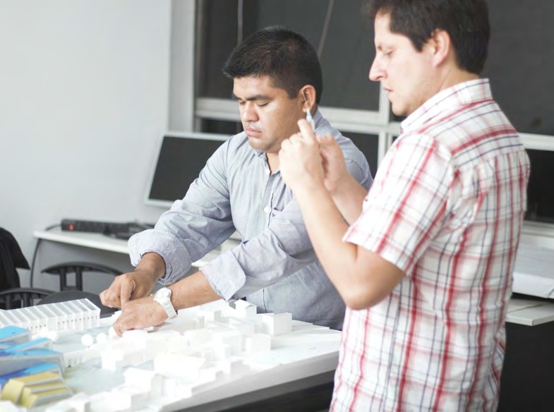 Equipo técnico de PROA8 Arquitectos trabajando con maqueta de proyecto